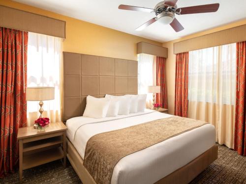 奥兰多Floridays Orlando Two & Three Bed Rooms Condo Resort的一间卧室配有一张大床和吊扇