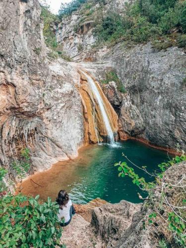 塔拉戈纳Paros的坐在瀑布旁的水池中的女人