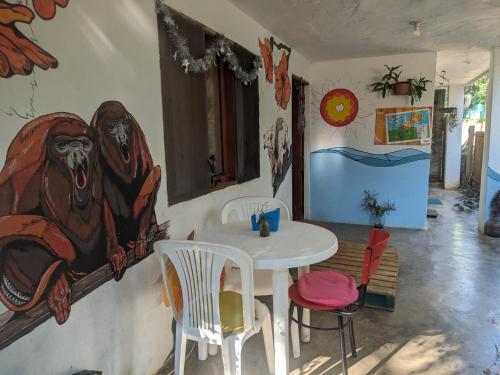 帕洛米诺Palomino EcoHouse & Camping的墙上挂着绘画的桌子和椅子