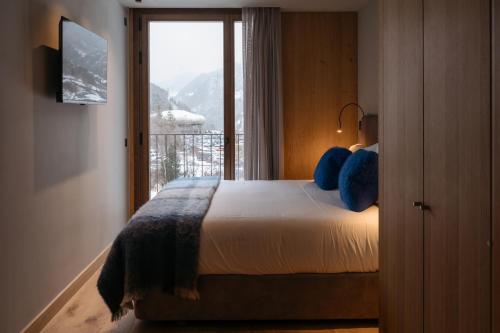 埃尔塔特ISARD RESIDENCES & SPA by Elegant Residences的一间卧室设有一张大床和大窗户