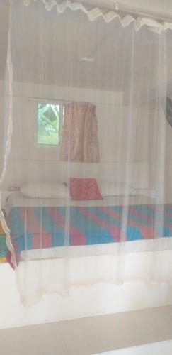 乌纳瓦图纳丛林乐园别墅的带窗户、床和窗帘的客房