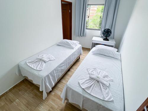 Lebrinhos hotel的一间卧室设有两张带白色床单的床和窗户。