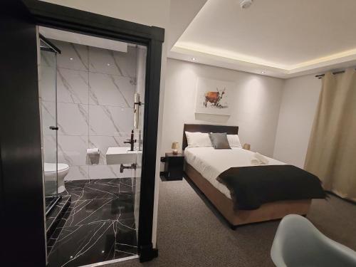 德班Durban Boutique Hotel的一间卧室配有一张床,浴室设有水槽