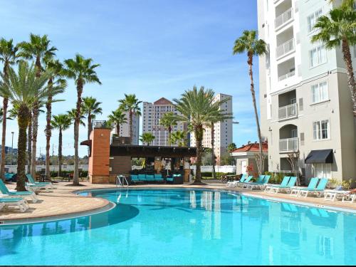 奥兰多环球影城蓬特套房酒店的一座棕榈树和椅子的大型游泳池
