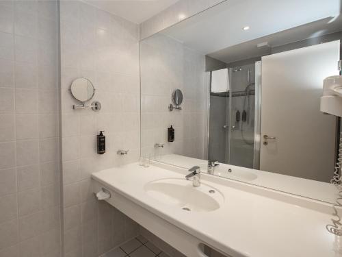 格赖夫斯瓦尔德Hotel Am Gorzberg Greifswald的白色的浴室设有水槽和镜子