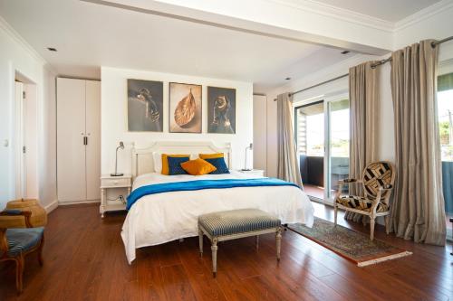 卡斯卡伊斯Marigold Cascais Villa的白色卧室配有床和椅子