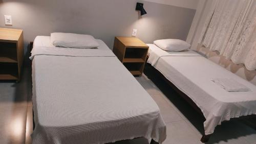 卡夸尔Hotel Darcisbel的小型客房设有两张单人床和窗户。