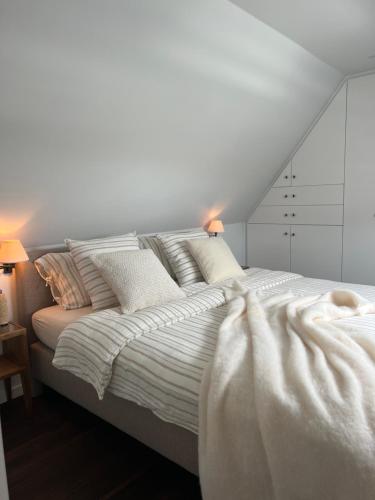 克诺克－海斯特luxe duplex met privé parking的白色卧室配有带白色床单和枕头的床