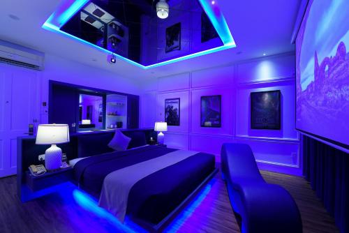 岘港Chiic House 3 - Khách sạn tình yêu的一间紫色卧室,配有一张床和一台电视