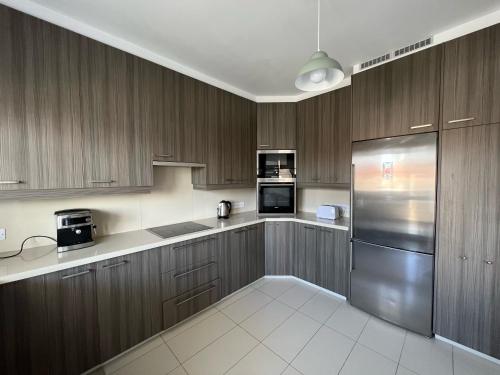 尼科西亚Majestic Boutique Apartment/2BR的厨房配有木制橱柜和不锈钢冰箱。