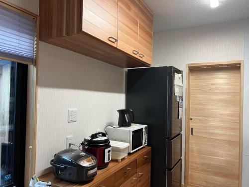 ゲストハウスみんちゅう的厨房配有黑色冰箱和微波炉。