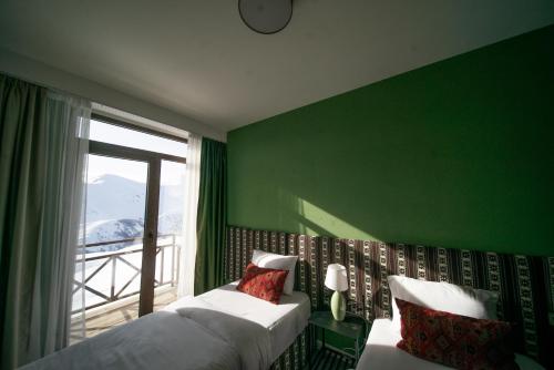 古多里Chalet Papa Basili的绿色卧室设有两张床和窗户