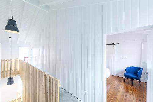 拉日什杜皮库Engenho Hostel的白色房间带蓝色椅子的走廊