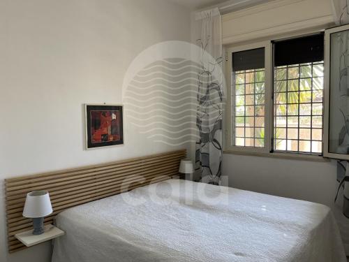托雷拉皮罗Villa Nah - Spiaggia a 250m的卧室配有白色的床和2扇窗户。