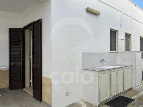 托雷拉皮罗Villa Nah - Spiaggia a 250m的白色的墙面厨房配有水槽和柜台