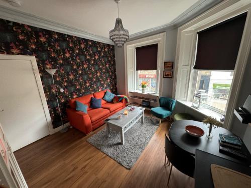 爱丁堡Edinburgh TWO BEDROOM apartment with free side street parking 24 hours的客厅配有橙色沙发和桌子