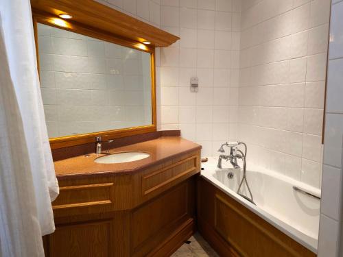 斯通Crown Hotel Stone的一间带水槽、浴缸和镜子的浴室