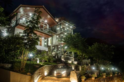 康提Kandy Victoria Eco Resort的夜间停在大楼前的汽车
