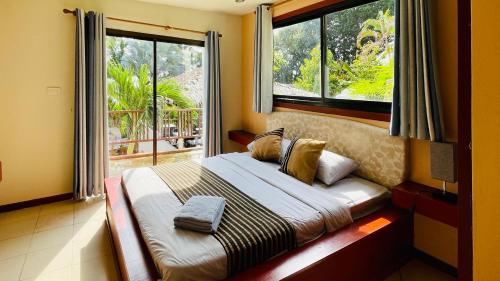 帕干岛Sojourn 6 bedroom villa near Full Moon Beach的一间卧室设有一张大床和大窗户