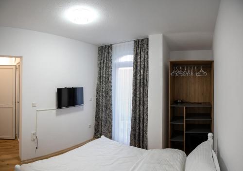 斯特鲁加Hotel Lux的卧室配有一张床,墙上配有电视。