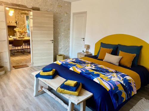 谢尔河畔圣乔治Le moulin du Mesnil的一间卧室配有一张蓝色和黄色的棉被,