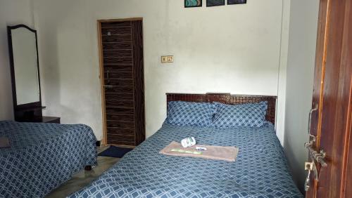 JaliapāraJarif st. Martin eco resort的一间卧室配有一张蓝色的床,上面有托盘
