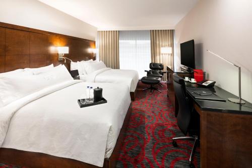 萨格奈OTL Gouverneur Saguenay的酒店客房配有两张床和一张书桌