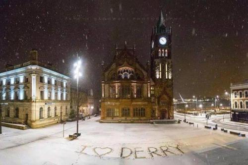 伦敦德里Helens House Derry City Centre Remarkable 3-Bed的一座大建筑,在雪中设有钟楼