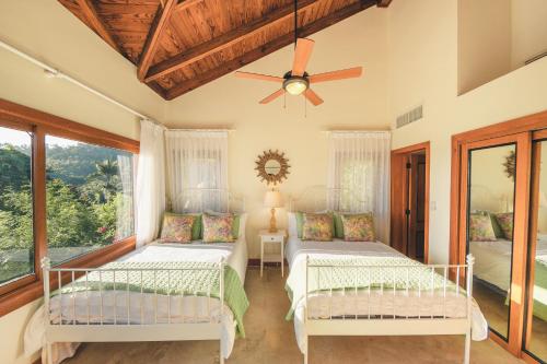 圣塔芭芭拉-山美纳Luxurious Villa at Puerto Bahia with Great Views的一间卧室配有两张床和吊扇