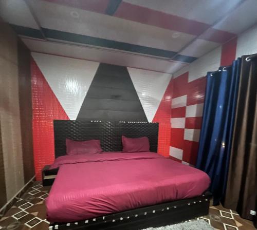 乔斯希马特Rupali home stay的卧室配有粉红色的床和条纹墙