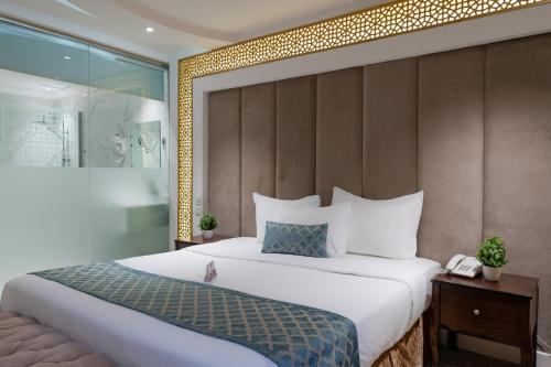 吉达Holiday Plus Al Salamh- هوليداي بلس السلامه的卧室配有一张白色大床和一堵墙