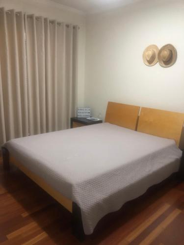 加乌拉Sunshine Room的一间卧室配有一张带白色床单的床和一扇窗户。