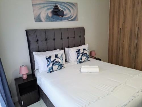 比勒陀利亚THE BLYDE Holiday Apartments的卧室配有一张白色大床和床头板