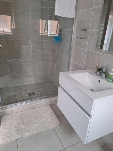 比勒陀利亚THE BLYDE Holiday Apartments的浴室配有白色水槽和淋浴。