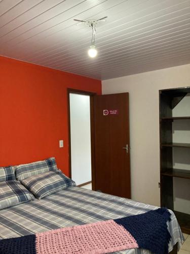 弗洛里亚诺波利斯Recanto das Pedras Floripa的一间卧室设有一张床和红色的墙壁