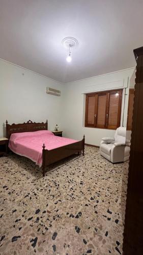 TerralbaCasa Corona - Appartamento affitto breve/lungo termine - casa vacanze的卧室配有粉红色的床和椅子