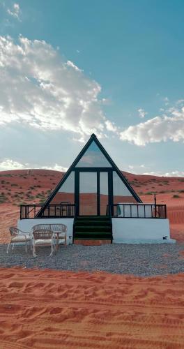 BadīyahMarbella bungalows desert的沙漠中一座有两长椅的建筑