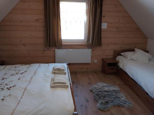 伊斯泰布纳Domek z widokiem的一间卧室配有床和带毛巾的窗户。