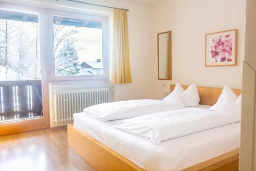 柯尼希斯湖畔舍瑙加尼太阳星酒店的窗户客房内的一张白色床