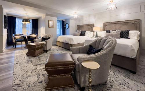 州学院Carnegie House的酒店客房带两张床和一张桌子以及椅子。