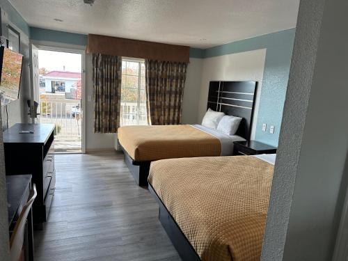 弗雷斯诺Siesta Inn的酒店客房设有两张床和窗户。