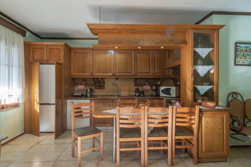 塞萨洛尼基Kassi Hanni Guesthouse的厨房配有木制橱柜和桌椅