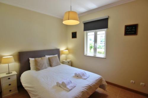 维拉摩拉Da Praia Apartment - Pool & Tenis的一间卧室配有一张床,上面有两条毛巾