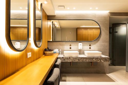 特里卡拉Ananti Resort & Spa的一间带两个盥洗盆和大镜子的浴室