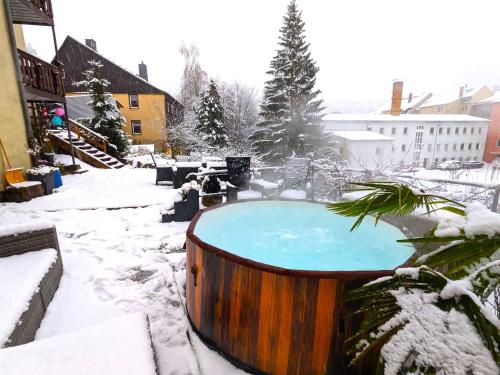 塞布尼茨Urlaubsmagie - Helle Wohnung mit Sauna & Pool & Whirlpool - F1的院子里的热水浴池,被雪覆盖