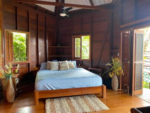 巴斯蒂门多斯ECO House with Sea View的卧室配有一张床铺,位于带木墙的房间内