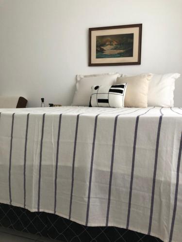 桑托斯Apto Praia的一张带黑白条纹毯子的床