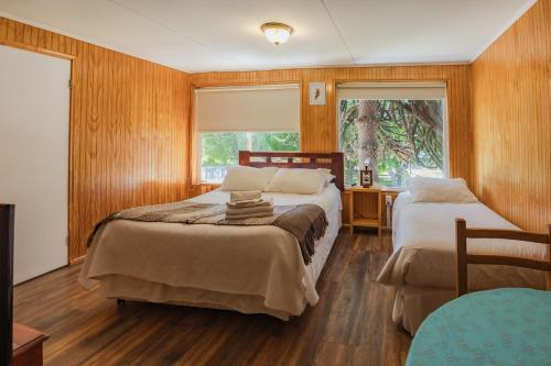 科伊艾科恩托苏尔旅馆的一间卧室设有两张床、一张桌子和一个窗口。