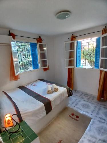阿格希尔Menzel Churasco Djerba的一间卧室设有一张床和两个窗户。