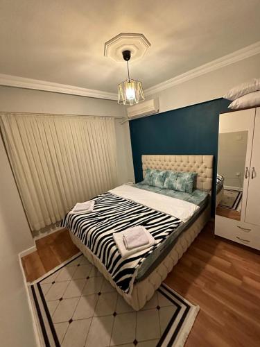 伊斯坦布尔Kadıköy Holiday Home的一间卧室设有一张蓝色墙壁的大床